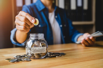 Woman puts a coin in a jar to save money for the future. after retirement and income, expenditure, savings and financial concepts