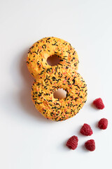 sweet dessert. round donuts with yellow icing isolated on white background and raspberries