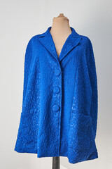 Blue embossed fabric jacket with blue buttons. Formal wear, autumn coat