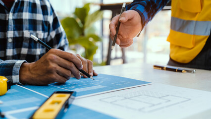 Architects or engineering work with blueprints and discuss projects together at the meeting in the office, and structural analysis of project types.