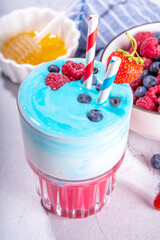 American independence holiday food, july 4 breakfast recipe idea, drink. Useful berry smoothie in white, blue, red colors, with blueberries, strawberries, raspberries on a white background