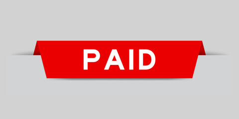 Red color inserted label with word paid on gray background