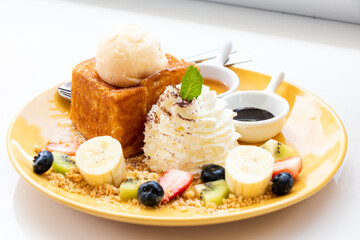 Honey toasted with ice cream, cream mousse and berry fruit on dish