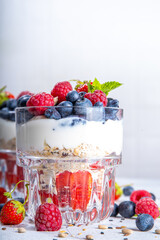 American independence holiday food, july 4 breakfast recipe idea. Summer diet healthy breakfast layered parfait dessert in a glass of yogurt, oatmeal, blueberries, strawberry berries