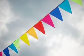 Ribbon with multi-colored triangular flags in the sky. Festive decorations. Good mood. Birthday. Anniversaries.