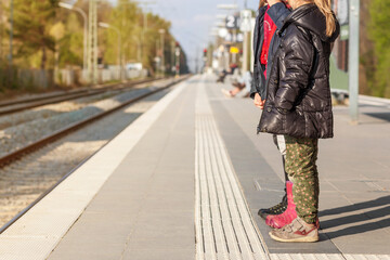 Safe Travel with Children in Europe. Children on Railway Station waiting Train. Safe Family Travel  by Public Transport.