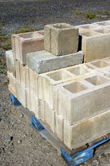 Cinder blocks, also called cement blocks, concrete blocks, or construction masonry units, on a wooden pallet