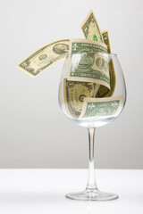 dollar banknotes money lies in an empty wine glass. business in the wine industry. alcohol marketing