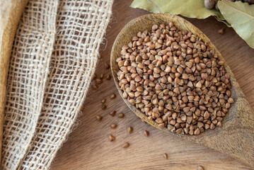 Buckwheat tea in a wooden spoon on a light wooden background. buckwheat porridge on a wooden spoon