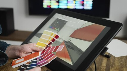 A professional graphic designer selects the color for the interior. A man works with modern equipment for designers and architects.