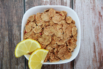 dry diet muesli with fruit in a white plate on a wooden background