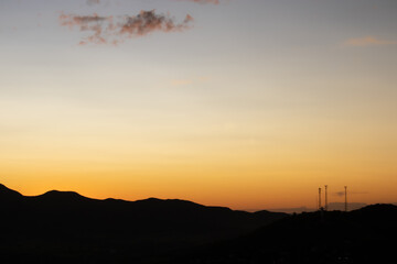 Orange sunset with mountains silhouette.