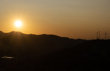 Orange sunset with mountains silhouette.