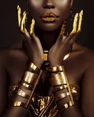 Kunst-Fantasie-Porträt afroamerikanische Frau. weibliche hände nahaufnahme, finger in goldener farbe. Mädchen-Königin Cleopatra-Stil. Griechische Goldarmbänder. Kreative metallische professionelle Make-up-Lippendiamanten glänzend © kharchenkoirina