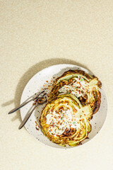 Homemade vegan cabbage steaks with herbs, spices, and sauce. Healthy food ready to eat