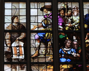Obraz na płótnie Canvas Amsterdam Nieuwe Kerk Church Stained Glass Window Close Up with a Man Holding the Amsterdam Coat of Arms, Netherlands
