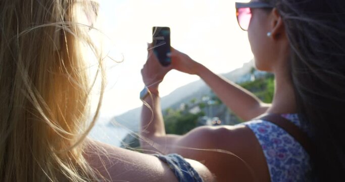 Two women relaxing enjoying summer vacation phone online technology