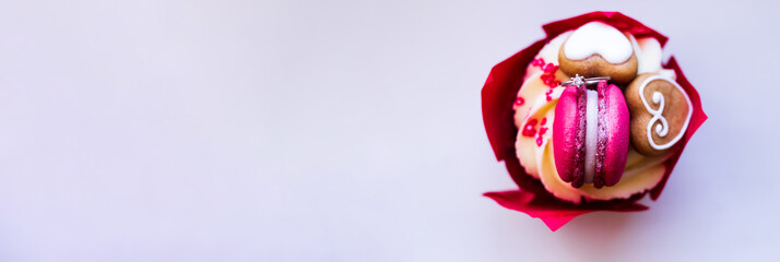 Appetizing red cupcake with a diamond ring inside for a marriage proposal on a light background....