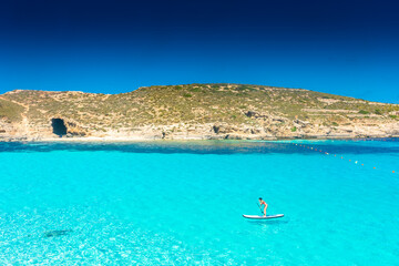 Comino, Malta, 22 May 2022:  Girl paddling on a sup in the Blue Lagoon
