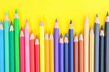 colored pencils with copy space on yellow background educational concept