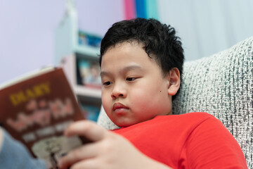 kid read book on sofa