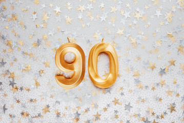 Number 90 ninety golden celebration birthday candle on Festive Background. ninety years birthday. concept of celebrating birthday, anniversary, important date, holiday