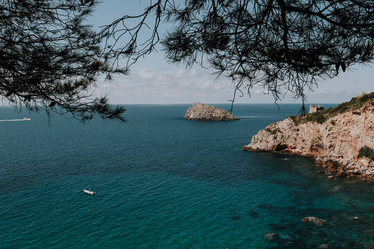 Eine Küste in Italien. Türkis blaues Meer. Kleines Boot im Wasser. Toskana