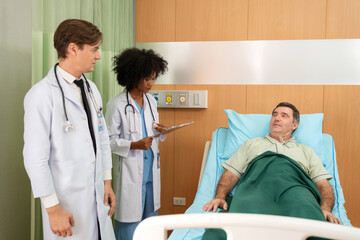 Elderly man lying on the bed in hospital. Doctor and nurse visit patient and talking on diagnosis and.treatment. Doctor encourages old man. Fully recover after successful surgery. Healthcare medical