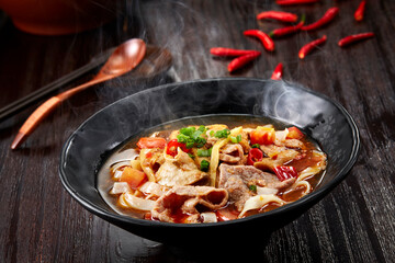Closeup of Chinese pork offal rice noodles on dark wooden table