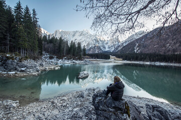 Beautiful reflection of the mountains in the lake. Lago di Fusine in winter time on the border of...