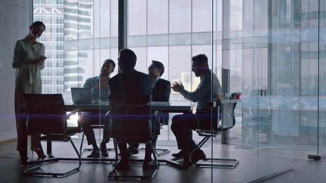 Office concept: young people cheering a mature businesswoman sitting at desk