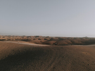 Fototapeta na wymiar Ein Pferd reitet durch die Wüste von Agafay. Drohnenaufnahme der Wüste - Marokko 1