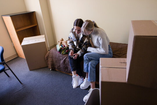 Young Female Roommates Moving Into College Dorm Room