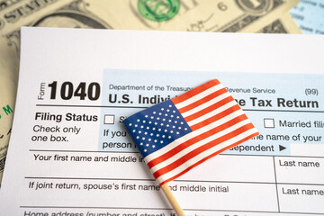 Tax Return form 1040 with USA America flag and dollar banknote, U.S. Individual Income.