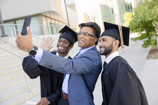 Happy male college graduates posing for photo