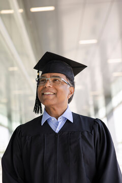 Happy mature male college graduate in cap and gown