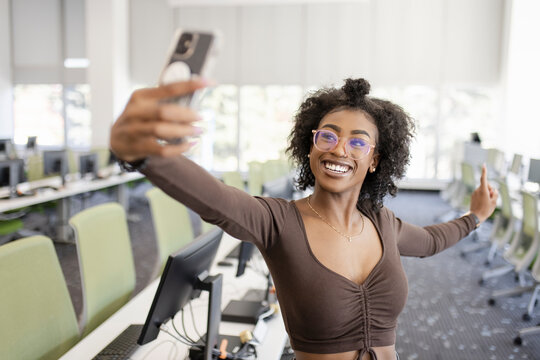 Portrait carefree young female college student taking selfie