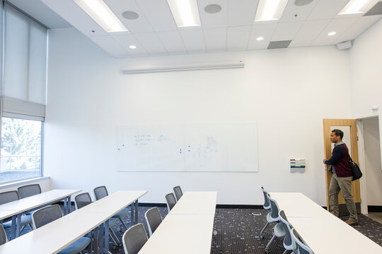 Male College Professor Entering Empty Classroom