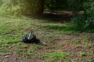 Garbage bag with plastic bottles in the middle of a forest. Concept of environmental pollution