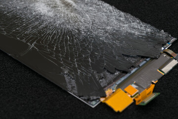 close-up of a broken smartphone screen on a black table in the process of repair