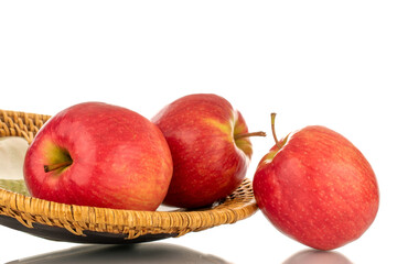 Three juicy red apples with a ceramic plate, close-up, isolated on a white background.