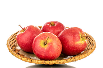 Four juicy red apples in a ceramic plate, close-up, isolated on a white background.
