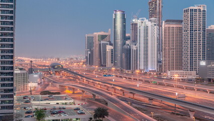 Fototapeta na wymiar Dubai Marina skyscrapers and Sheikh Zayed road with metro railway aerial night to day timelapse, United Arab Emirates