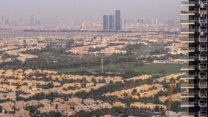 Aerial view of housing development promenade with JLT district skyscrapers and artificial lake with...