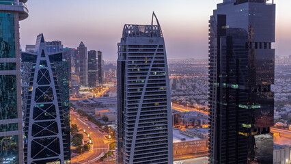Obraz premium Tall residential buildings at JLT aerial night to day timelapse, part of the Dubai multi commodities centre mixed-use district.
