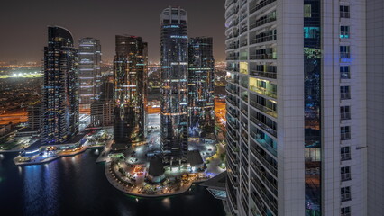 Tall residential buildings at JLT aerial night timelapse, part of the Dubai multi commodities centre mixed-use district.