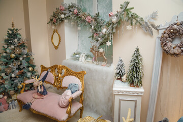 Merry Christmas decorated room. Festive interior with fir tree, pink sofa, wooden toys, icy roses. Wrapped presents