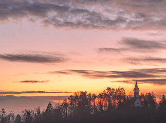 Vivid sunrise over the church on a misty morning on Bled