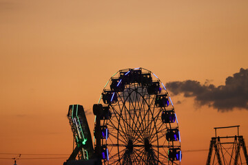 Ferris wheel in the evening time with the orange environment.
