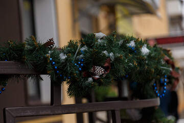 handrail decorated with green tinsel garland, blue beads and fir cones for Christmas, New Year...